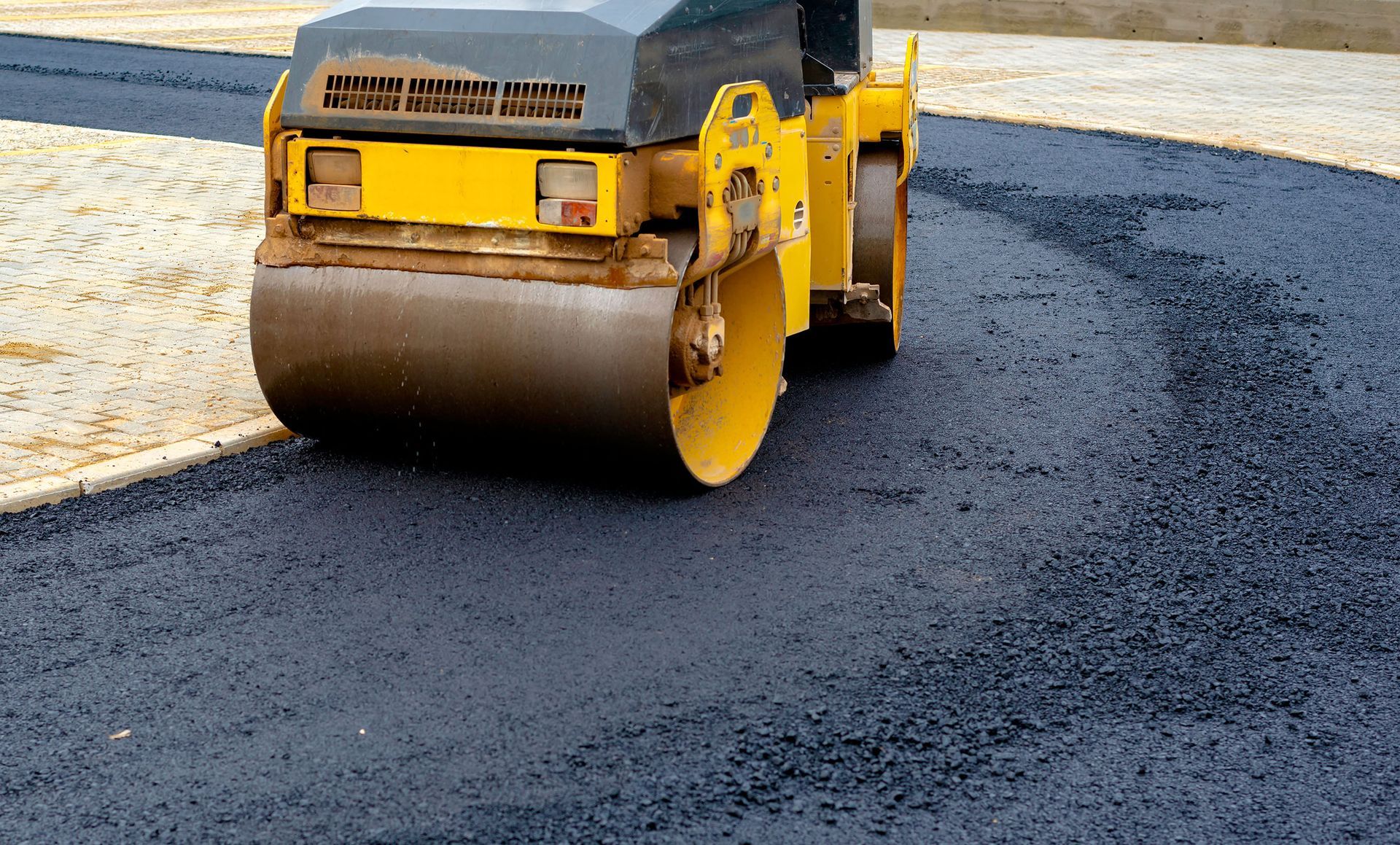Fresh asphalt being rolled on a paving job